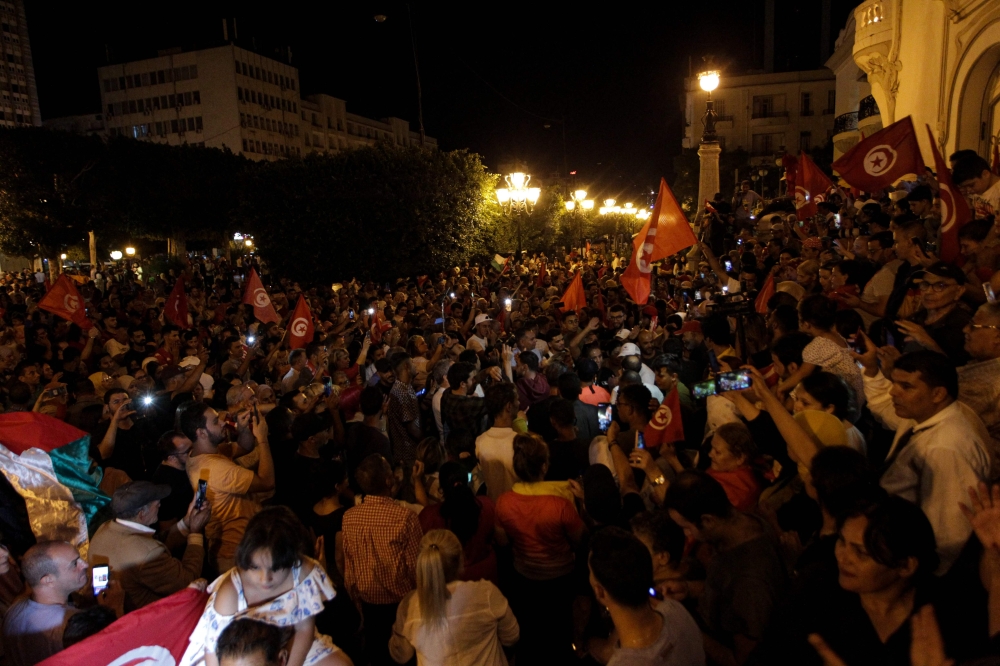 Supporters of Tunisia's President celebrate after the announcement of the first estimates in favor of the incumbent President, during Tunisia's Presidential election, on the Avenue Habib Bourguiba in Tunis on October 6, 2024. (Photo by YASSINE MAHJOUB / AFP)
