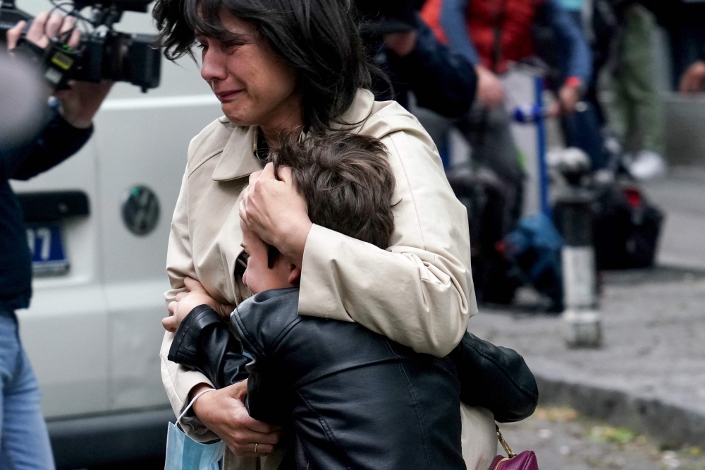 File photo. A parent escorts her child following a shooting at a school in the capital Belgrade on May 3, 2023. (Photo by Oliver Bunic / AFP)

