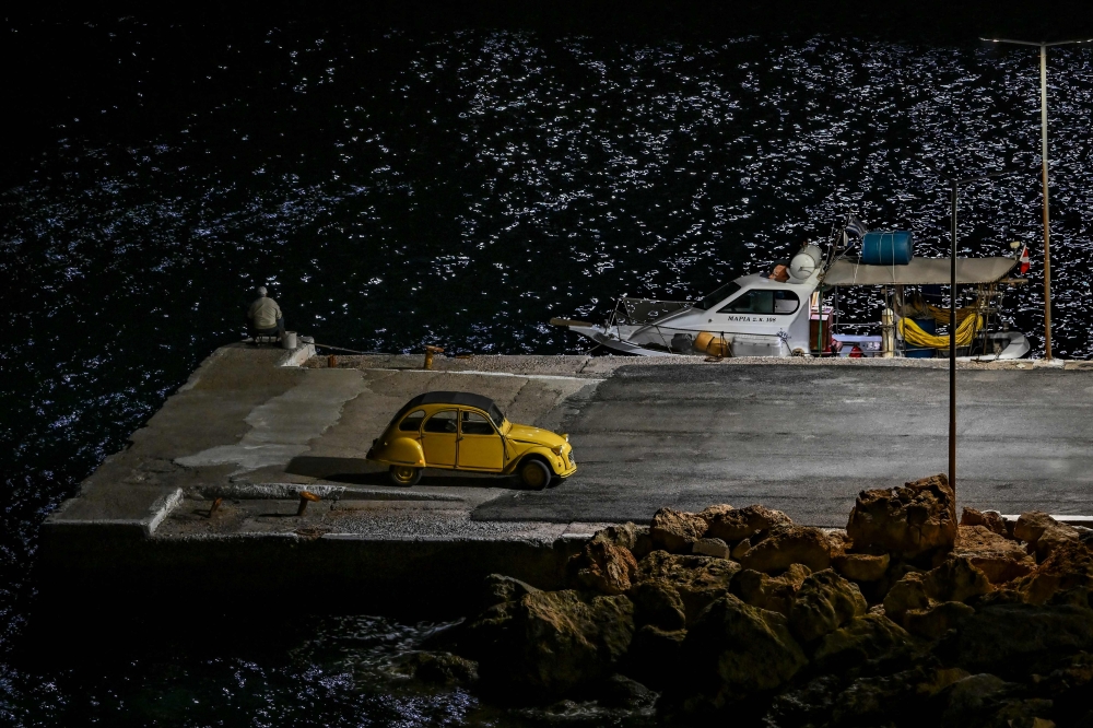 A man fishes at the harbour on the small island of Antikythera, on September 16, 2024. Photo by Aris MESSINIS / AFP