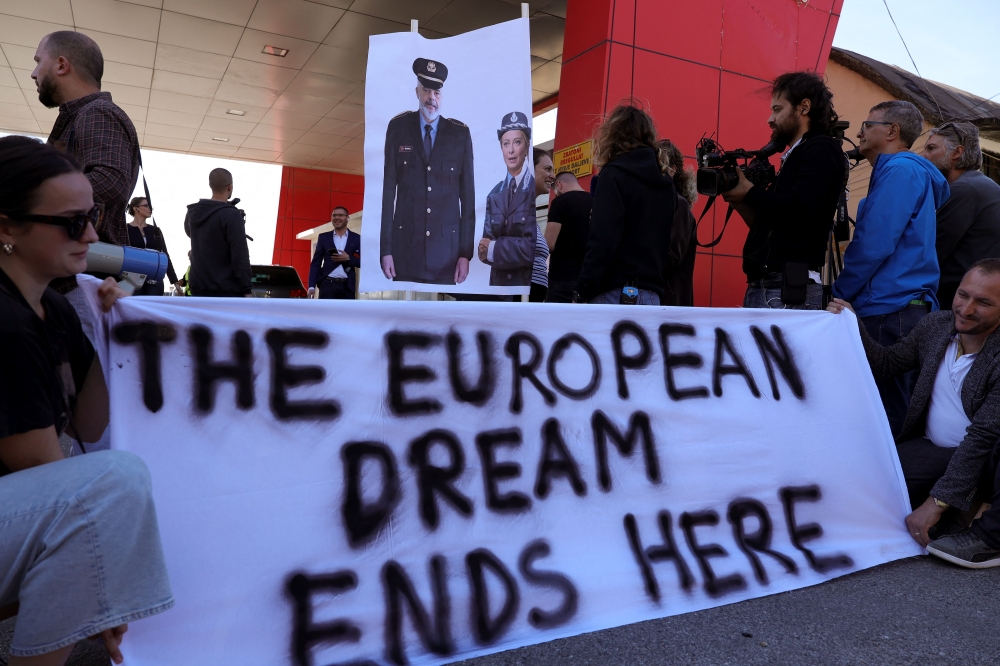 A group of civil rights activists gather in protest, after the first group migrants intercepted in Italian waters, arrived at Shengjin port in Albania on October 16, 2024. (Photo by Adnan Beci / AFP)