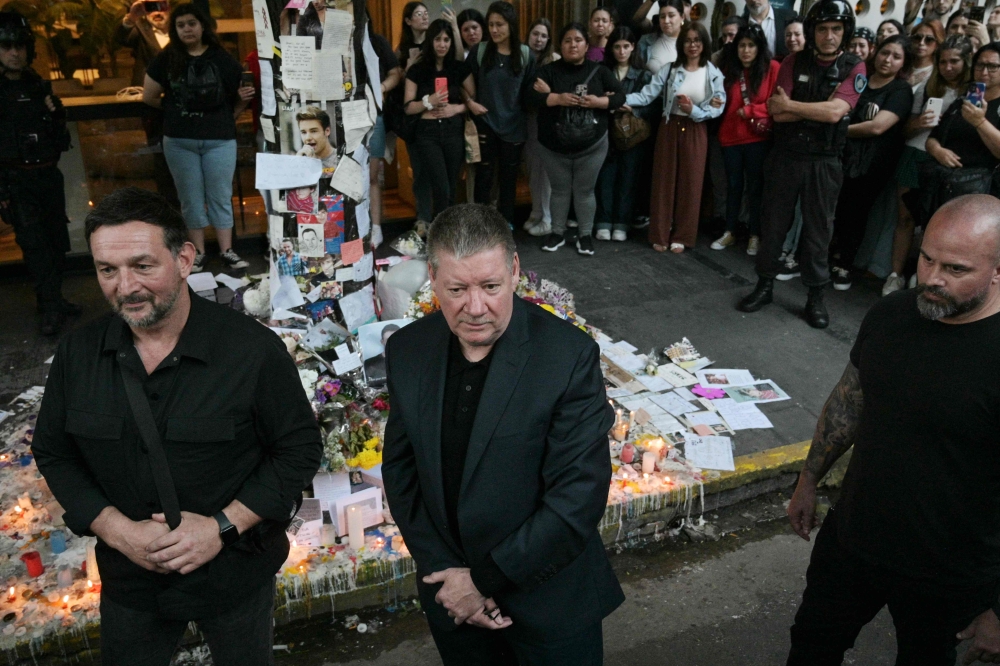 Geoff Payne (C), the father of One Direction pop singer Liam Payne, walks in front of the place where fans paid tribute to his late son outside the CasaSur Hotel in Buenos Aires on October 18, 2024. (Photo by Juan Mabromata / AFP)
