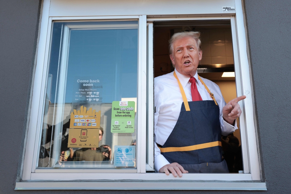 Republican presidential nominee, former US President Donald Trump answers questions as he works the drive-through line as he visits a McDonald's restaurant on October 20, 2024 in Feasterville-Trevose, Pennsylvania. (Photo by Win McNamee/Getty Images via AFP)