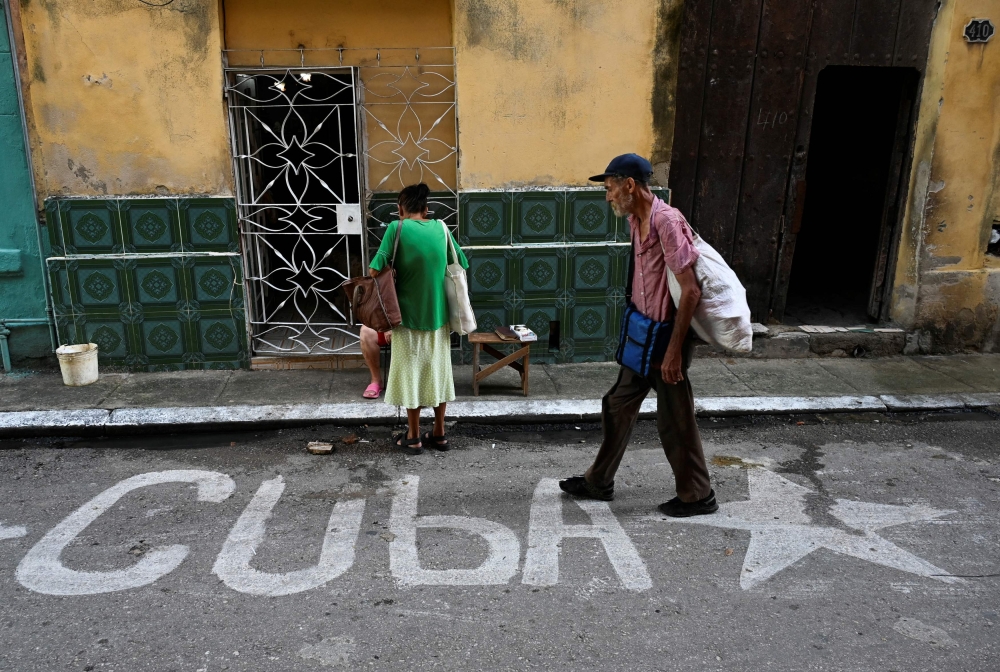 A man walks down a street in Havana on October 22, 2024. (Photo by Yamil Lage / AFP)
