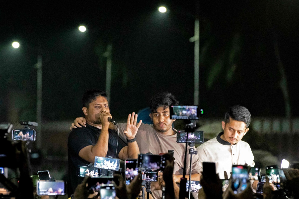 Student leaders and activists Hasnat Abdullah (L), Rifat Rashid (C) and Sarjis Alam address protestors during a demonstration outside the residence of Bangladesh's president Sahabuddin Chuppu, demanding his resignation amid accusations of his residual loyalty to the toppled premier Sheikh Hasina, in Dhaka on October 22, 2024. (Photo by Abdul Goni / AFP)
