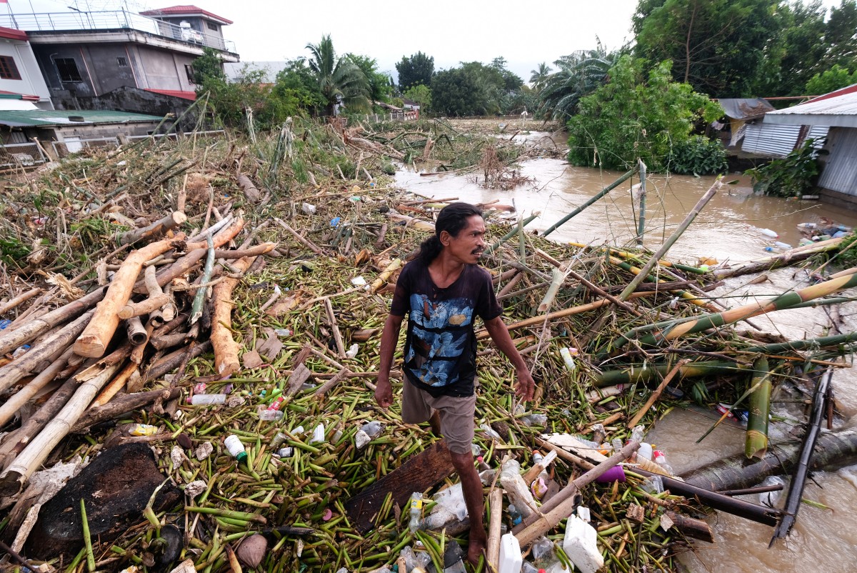  A man walks along the debris from the floods brought about by Tropical Storm Trami in Nabua, Camarines Sur on October 25, 2024. Photo by ZALRIAN SAYAT / AFP