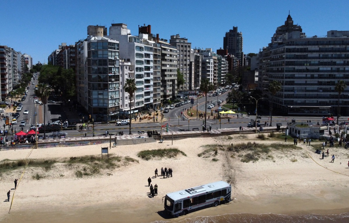 Aerial view showing a bus that ran into the beach in Pocitos neighbourhood in Montevideo, on October 26, 2024. At least 15 people were injured, while the cause of the accident is still to be determined. (Photo by Nicolas GARCIA / AFP)
