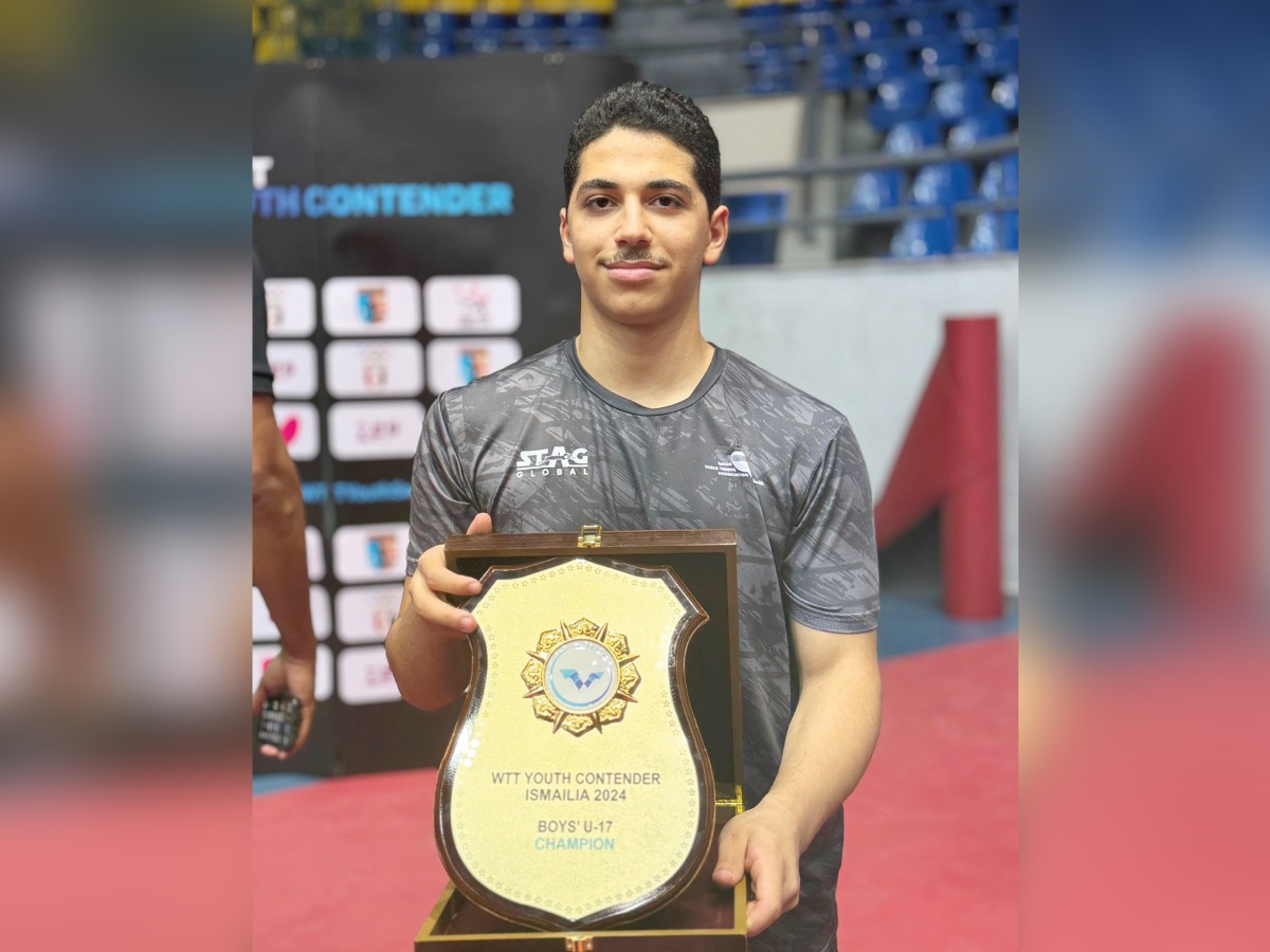 Qatar's Ahmed Korani celebrates with the trophy after winning the boys' U-17 title.
