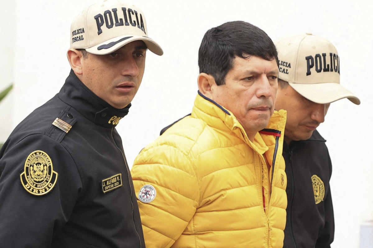 Picture distributed by the Peruvian national news agency Andina of Agustin Lozano (C), President of the Peruvian Football Federation (FPF), being arrested in Lima on November 7, 2024. (Photo by Jhonel RODRIGUEZ / ANDINA / AFP)
