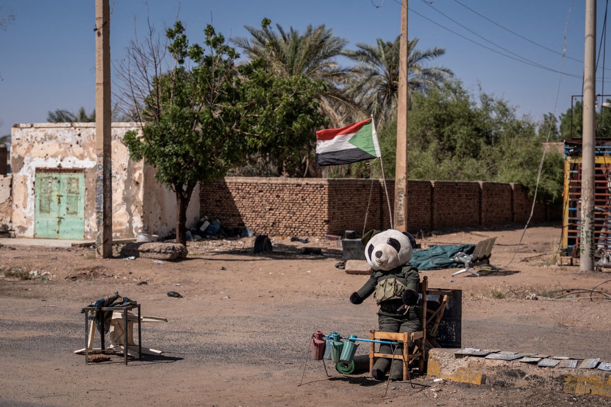 A stuffed panda and a Sudanese flag are placed at a military checkpoint in Khartoum North on November 3, 2024. Sudan's war erupted in April 2023 between the regular army led by Burhan and the paramilitary Rapid Support Forces (RSF), led by his former deputy, Mohamed Hamdan Daglo. (Photo by Amaury Falt-Brown / AFP)
