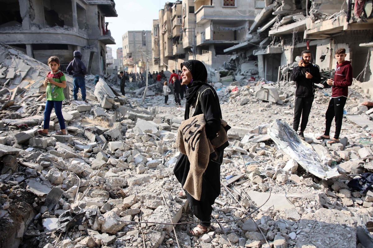 Palestinians walk amid the destruction following an Israeli strike in Jabalia in the northern Gaza Strip on November 10, 2024. (Photo by Omar AL-QATTAA / AFP)