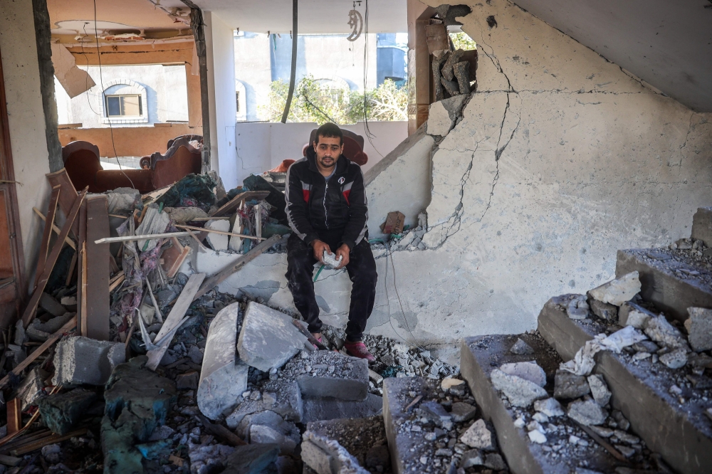 A man reacts as he sits in a heavily damaged building following an Israeli strike in Deir Al-Balah in the central Gaza Strip on November 15, 2024. (Photo by Eyad Baba / AFP)