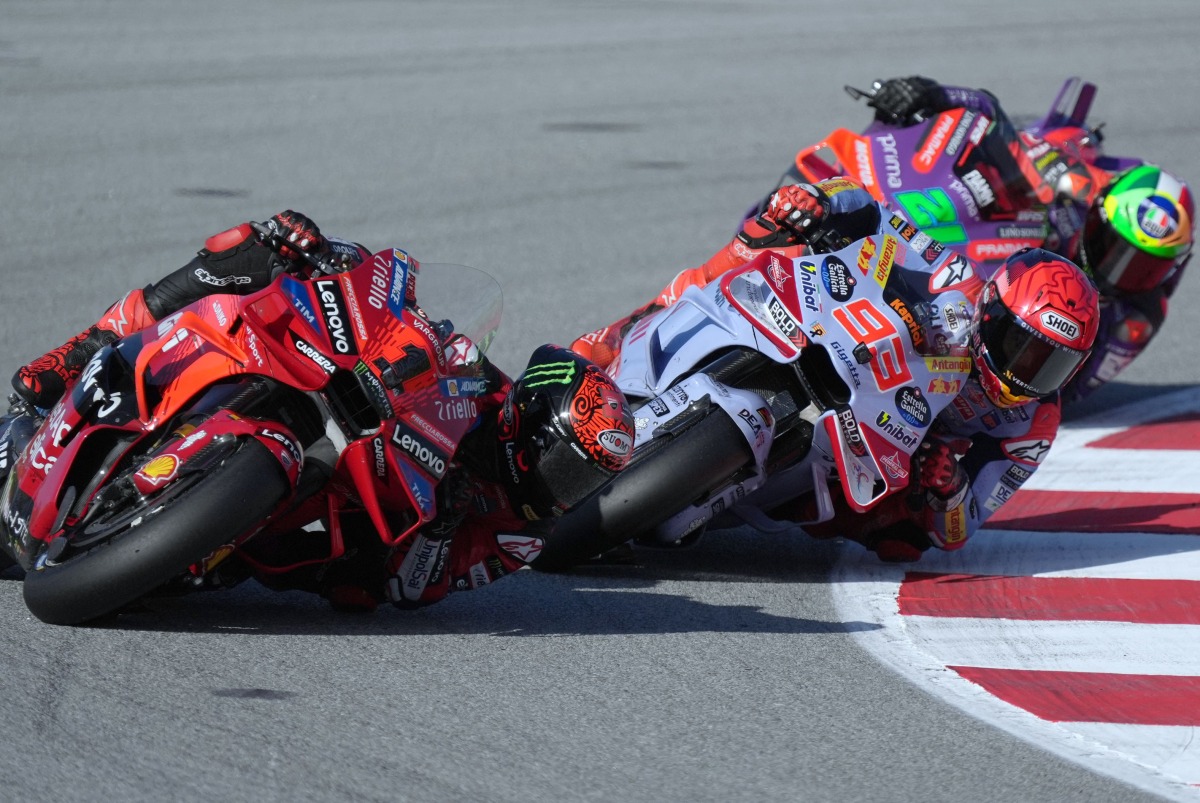 Ducati Italian rider Francesco Bagnaia rides ahead of Ducati Spanish rider Marc Marquez and Ducati Italian rider Franco Morbidelli during the Moto GP qualifying session for the Solidarity Grand Prix of Barcelona at the Circuit de Catalunya on November 16, 2024 in Montmelo on the outskirts of Barcelona. (Photo by Manaure Quintero / AFP)
