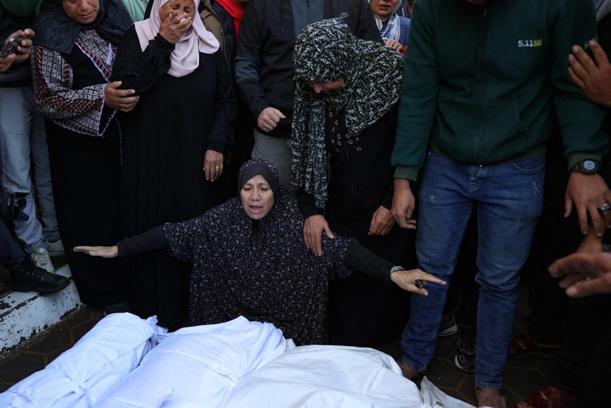 A Palestinian woman reacts in front of the bodies people killed in an Israeli strike, at the al-Aqsa Martyrs Hospital in Deir Al-Balah in the central Gaza Strip on November 17, 2024. (Photo by BASHAR TALEB / AFP)
