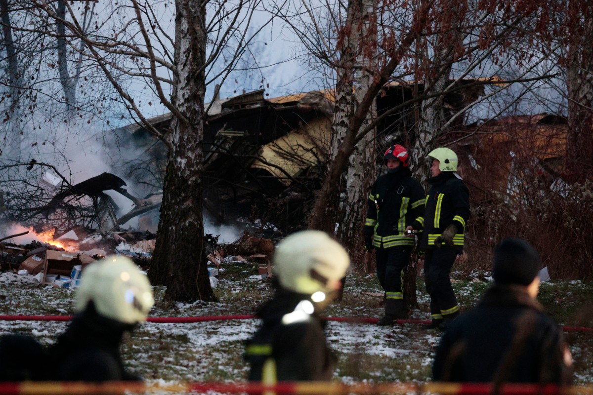 Lithuanian rescuers work next to the wreckage of a cargo plane following its crash near the Vilnius International Airport in Vilnius on November 25, 2024. A cargo plane flying from Germany to Lithuania crashed early on November 25, 2024 near the airport of the capital Vilnius killing one person, firefighters said. Photo by Petras MALUKAS / AFP.

