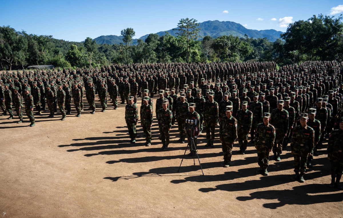 (FILES) This photo taken on November 9, 2024 shows members of Ta'ang National Liberation Army (TNLA) receiving military equipments at a graduation ceremony after getting special combat training for three months in a secret jungle near Namhkam, Myanmar's northern Shan State. (Photo by AFP)
