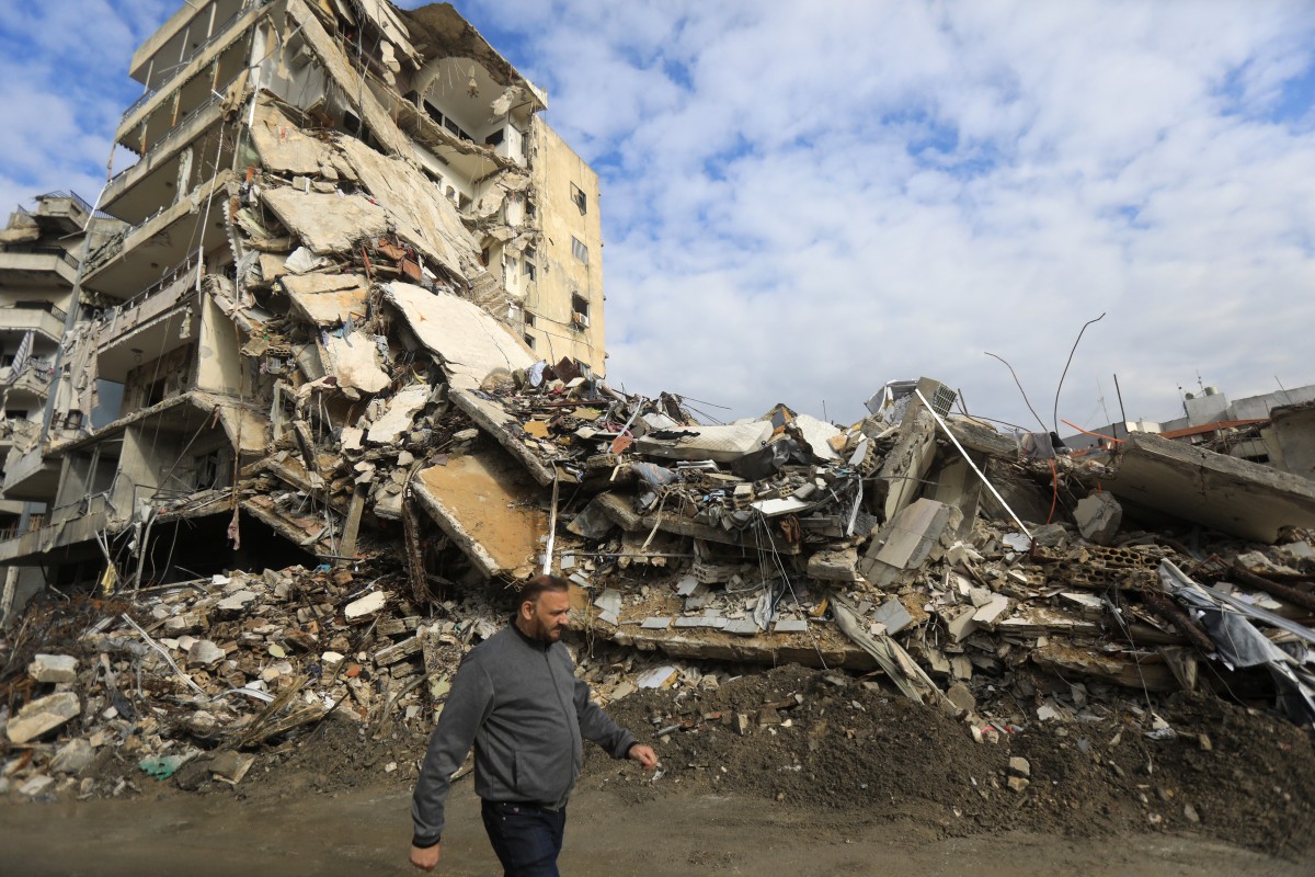 This picture taken a day after a ceasefire between Israel and Hezbollah shows a man walking past destroyed buildings in the southern Lebanese city of Nabatieh on November 28, 2024. Photo by AFP.