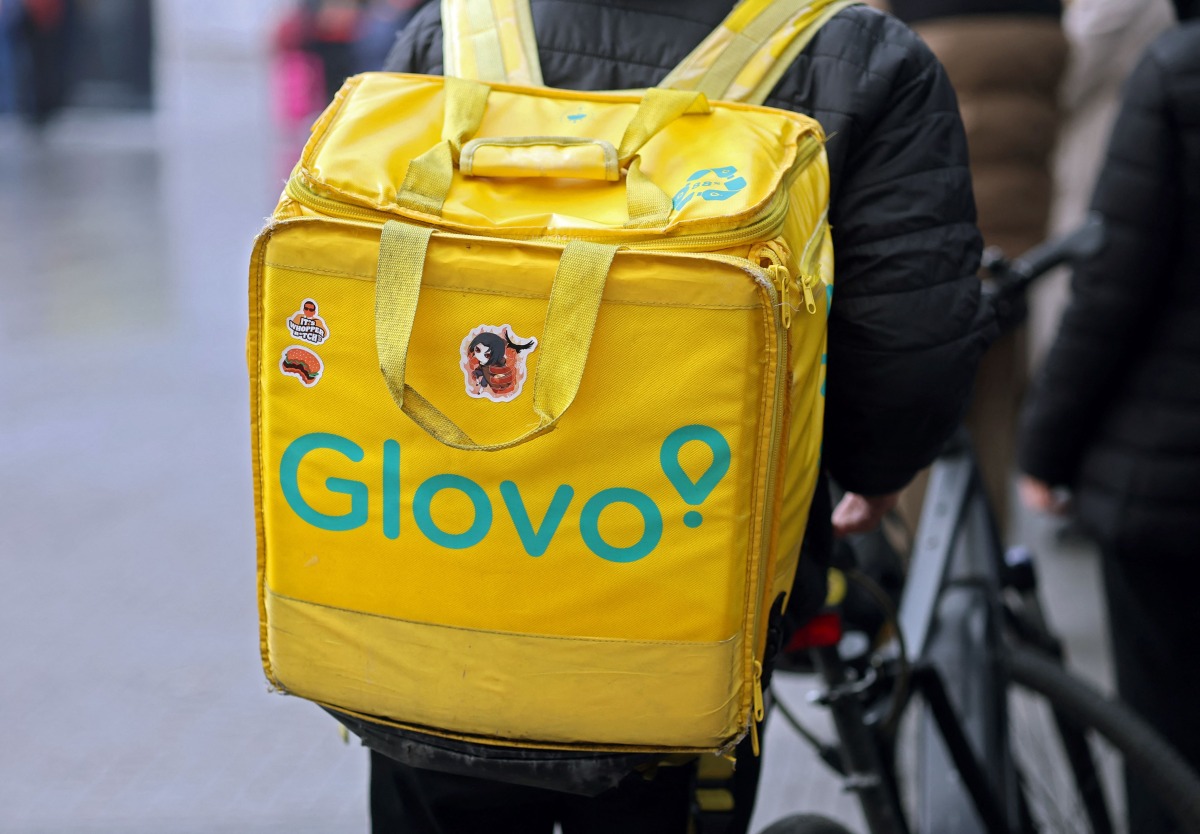 A food delivery firm Glovo's rider carries his bag in Madrid on December 2, 2024. Following a Spanish government pressure, Glovo company in Spain gives to their employees a labour contract. (Photo by Thomas COEX / AFP)
