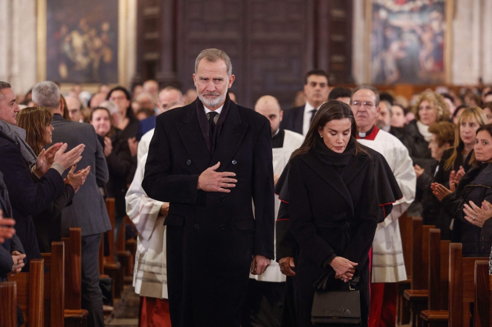 King Felipe VI of Spain (left) and his wife Queen Letizia arrive to attend a funeral mass held on December 9, 2024 at the Cathedral of Valencia in memory of the victims of the deadly floods that devastaded the region in late October. (Photo by Kai Fosterling / POOL / AFP)