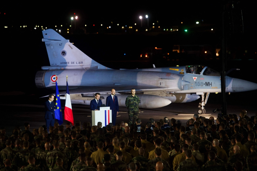 France's President Emmanuel Macron (second left) gives a speech to French soldiers at an airbase in Djibouti on December 20, 2024. (Photo by Nicolas Messyasz / POOL / AFP)