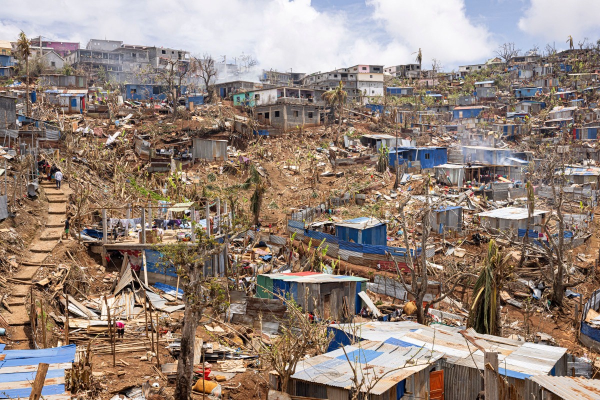 This photograph shows a general view of damaged shelters and houses in the town of Vahibe, on the outskirts of Mamoudzou, on the French Indian Ocean territory of Mayotte, on December 24, 2024, a week after the cyclone Chido's passage over the archipelago. (Photo by PATRICK MEINHARDT / AFP)
