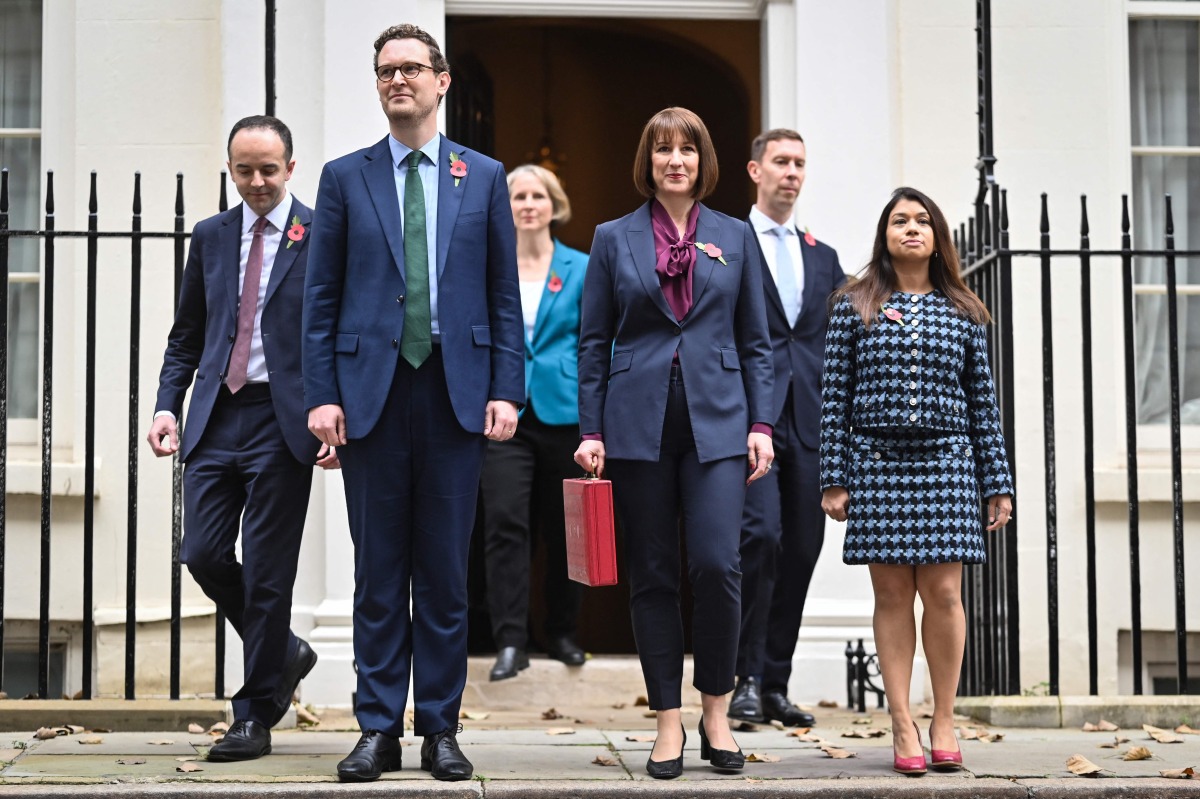 (FILES) Britain's Chancellor of the Exchequer Rachel Reeves (C), holding the red Budget Box, poses with members of her Treasury team, Parliamentary Secretary Emma Reynolds (3L), Exchequer Secretary James Murray (L), Chief Secretary to the Treasury Darren Jones (2L), Economic Secretary Tulip Siddiq (R) and Financial Secretary Spencer Livermore outside of 11 Downing Street, in central London, on October 30, 2024, to present the government's annual Autumn budget to Parliament. (Photo by JUSTIN TALLIS / AFP)
