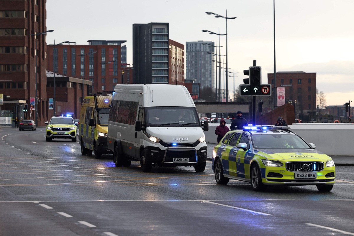 A Prison van escorted by police arrives at The Queen Elizabeth II Law Courts in Liverpool, north west England on January 23, 2025, ahead of the sentencing Southport attacker Axel Rudakubana. (Photo by Darren Staples / AFP)
