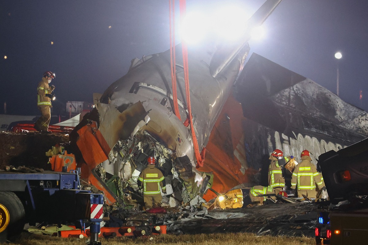 File: Firefighters and rescue personnel work near the scene where a Jeju Air Boeing 737-800 series aircraft crashed and burst into flames at Muan International Airport in South Jeolla Province, some 288 kilometers southwest of Seoul on December 29, 2024. (Photo by Yonhap / AFP)

