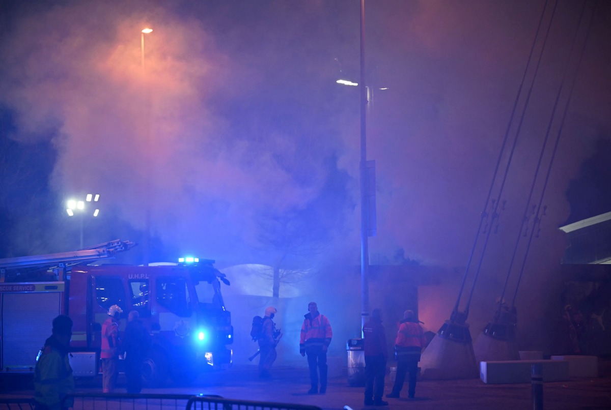 Members of the fire brigade extinguish a fire at merchandise stall outside the Etihad Stadium in Manchester, north west England, on January 29, 2025, ahead of the UEFA Champions League football match between Manchester City and Club Brugge. (Photo by Paul ELLIS / AFP)

