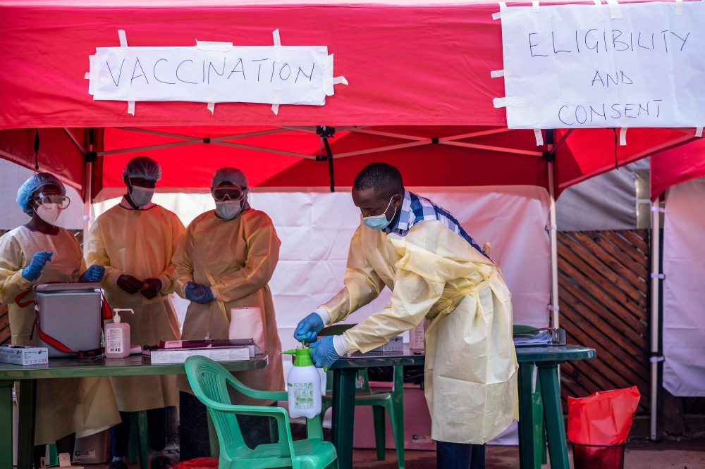 Medical personnel wear protective medical clothing while disinfecting the area in preparation for the arrival of volunteers during the launch of an Ebola trial vaccination campaign at Mulago Referral Hospital in Kampala on February 3, 2025. (Photo by Badru Katumba / AFP)
