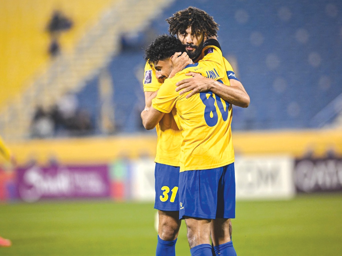 Al Gharafa's Ferjani Sassi celebrates with Ahmed Al Ganehi after scoring a goal.
