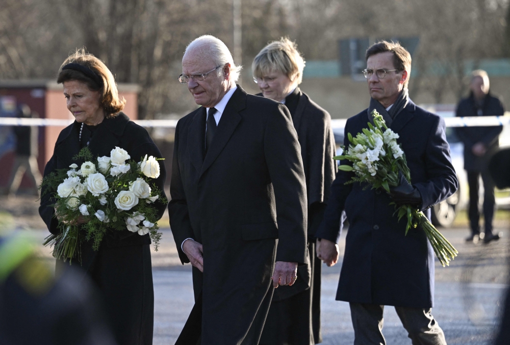From left: Sweden's Queen Silvia and King Carl XVI Gustaf of Sweden, Prime Minister Ulf Kristersson with his wife Birgitta Ed arrive at the memorial to place flowers outside the adult education center Campus Risbergska school in Orebro, Sweden, on February 5, 2025. (Photo by Jonathan Nackstrand / AFP)