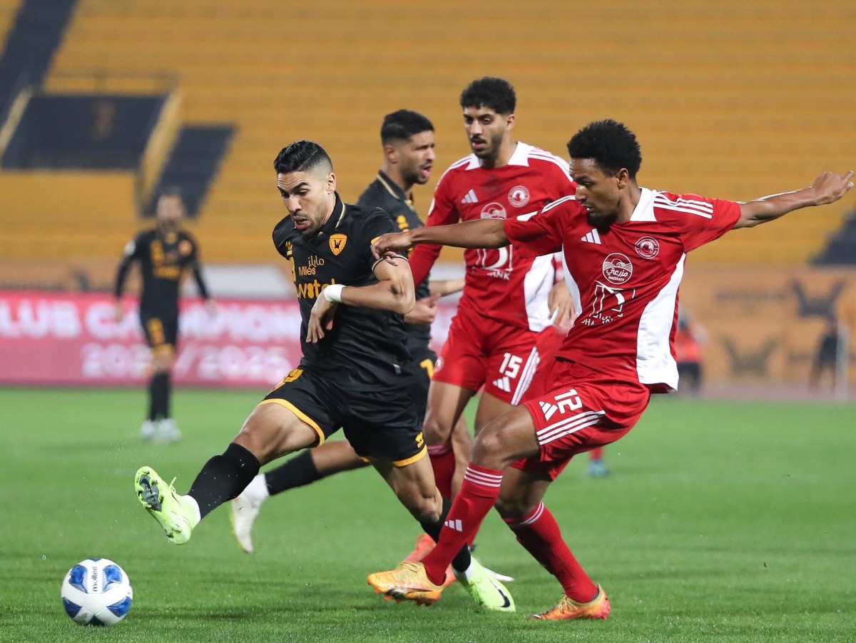 Al Arabi players challenge an Al Qadsia player during the match.