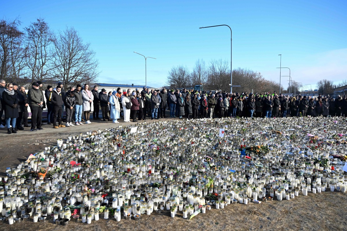 People gather at a makeshift memorial to observe a national minute's silence to honor the victims of the February 4 school shooting in Orebro, Sweden on February 11, 2025. (Photo by Jessica GOW / TT News Agency / AFP) / Sweden OUT
