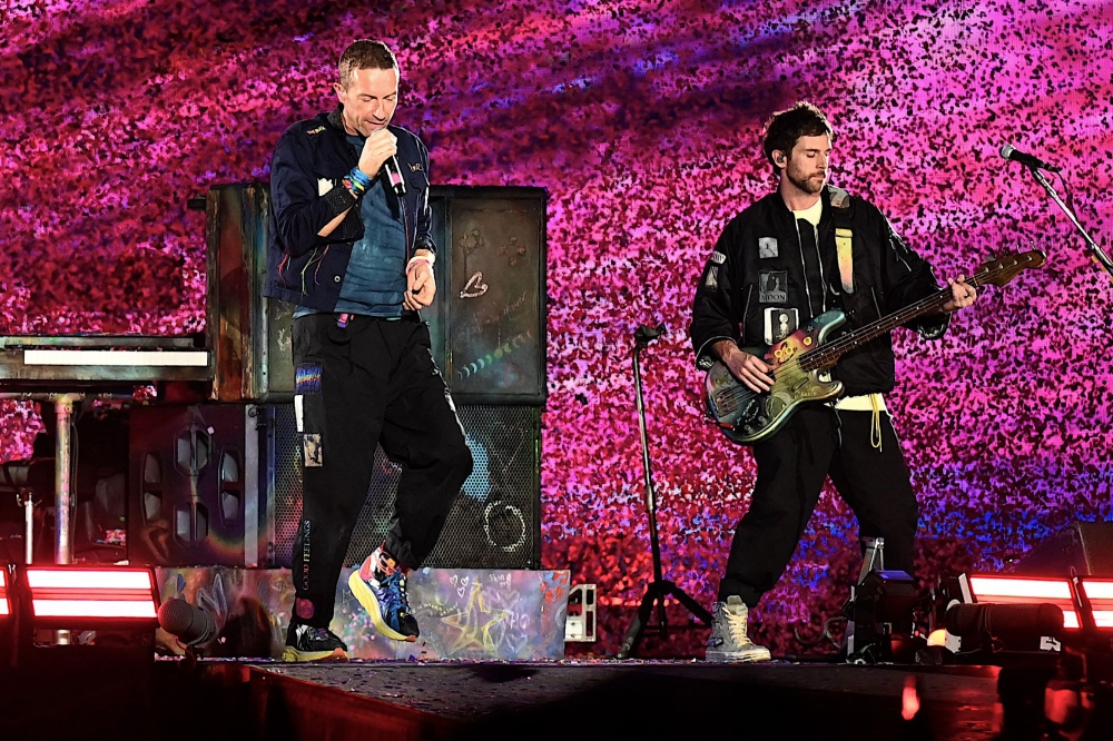 (Files) Chris Martin (L) of the British rock band Coldplay performs onstage during a concert, at the DY Patil stadium in Navi Mumbai on January 18, 2025. (Photo by Sujit Jaiswal / AFP) 