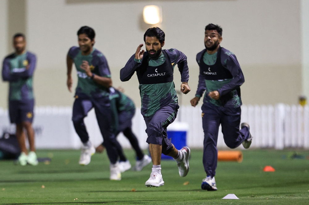 Pakistan's captain Mohammad Rizwan (front) and his teammates warm up during a practice session at the ICC Academy groud in Dubai on February 21, 2025. (Photo by Fadel Senna / AFP)