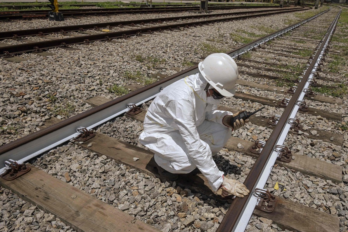 An Employee of ViaMobilidade - a company that manages subway and train lines in the Sao Paulo metropolitan area - takes the temperature of railway tracks in Osasco, Sao Paulo state, Brazil on February 24, 2025. (Photo by Nelson ALMEIDA / AFP)
