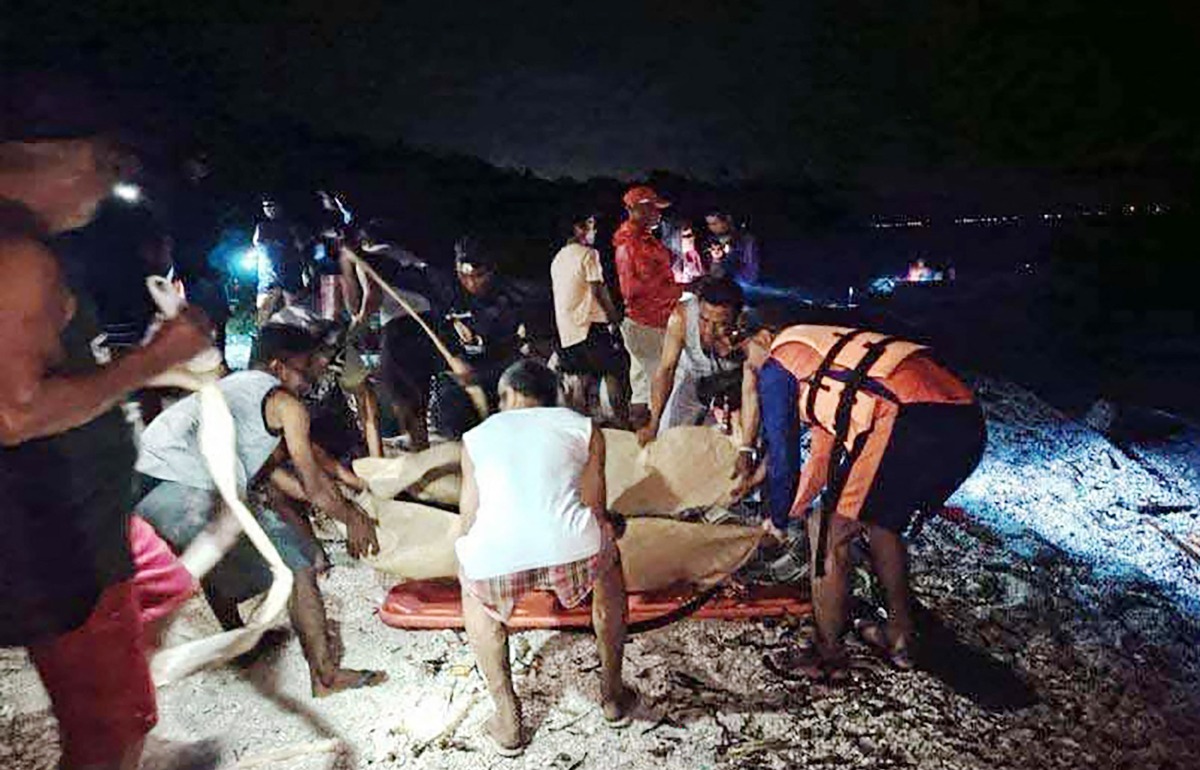 This handout photo taken February 27, 2025 and released by the Philippine Coast Guard February 28, shows coast guard personnel and rescuers placing recovered bodies of two Russian divers on stretchers near Verde Island, in Batangas City, south of Manila. (Photo by Handout / Philippine Coast Guard (PCG) / AFP)