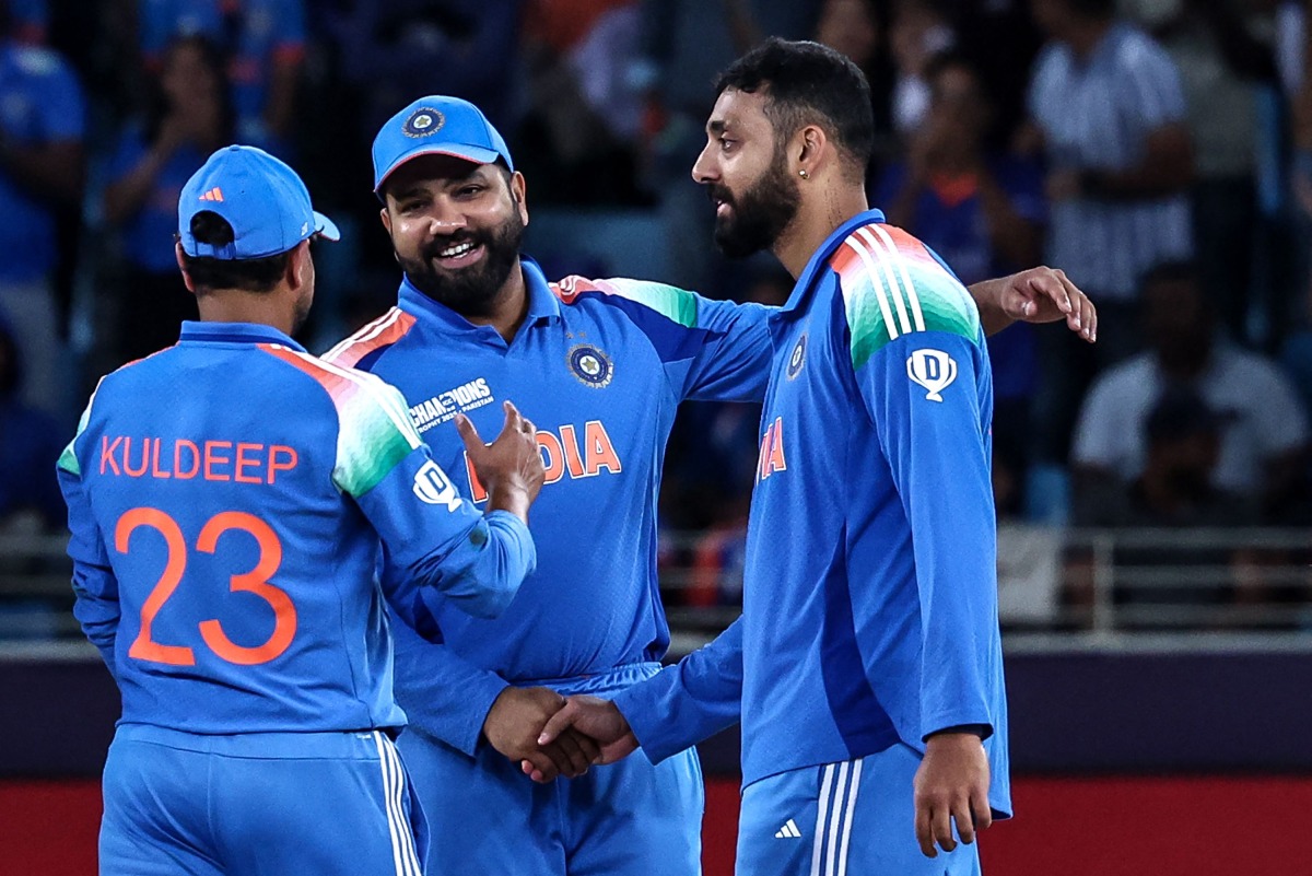 India's Varun Chakravarthy (R) celebrates with teammates after taking the wicket of New Zealand's captain Mitchell Santner during the ICC Champions Trophy one-day international (ODI) cricket match between New Zealand and India at the Dubai International Stadium in Dubai on March 2, 2025. (Photo by FADEL SENNA / AFP)
