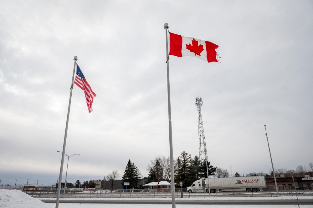 (Files) The Canadian and US flags fly near the Canada-US border in Blackpool, Quebec, Canada, on February 2, 2025.  (Photo by Andrej Ivanov / AFP)