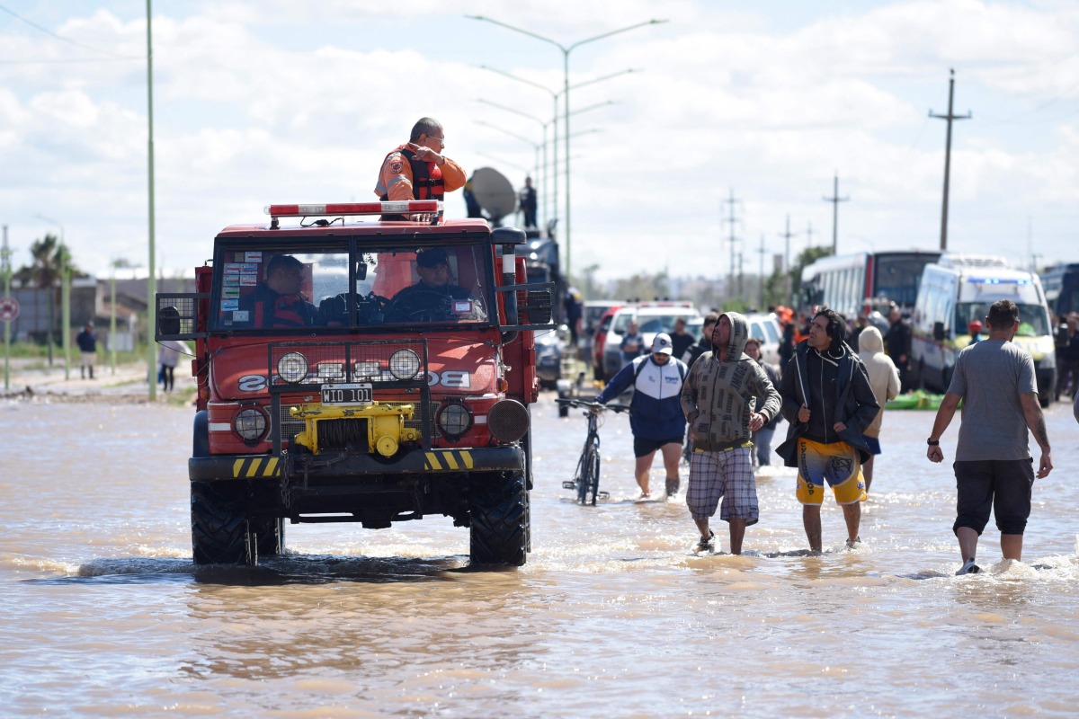 People is transported on a police boat through flooded waters the day after a heavy storm in Bahia Blanca, 600 km south of Buenos Aires on March 8, 2025. At least ten people died and more than 1,000 were evacuated in the Argentine port city of Bahia Blanca as torrential rains flooded homes and hospitals, destroyed roads and forced authorities to cut the power. (Photo by PABLO PRESTI / AFP)
