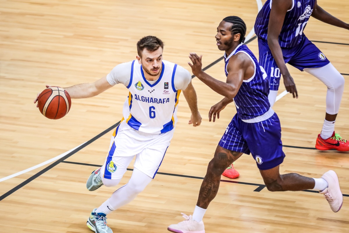 Al Gharafa's Nedim Muslic dribbles past an Al Khor player.
