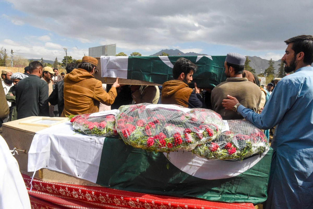People carry the coffins of railwaymen killed by armed militants who ambushed a train in the remote mountainous area of Balochistan province, during their funeral in Quetta on March 13, 2025. (Photo by Banaras KHAN / AFP)
