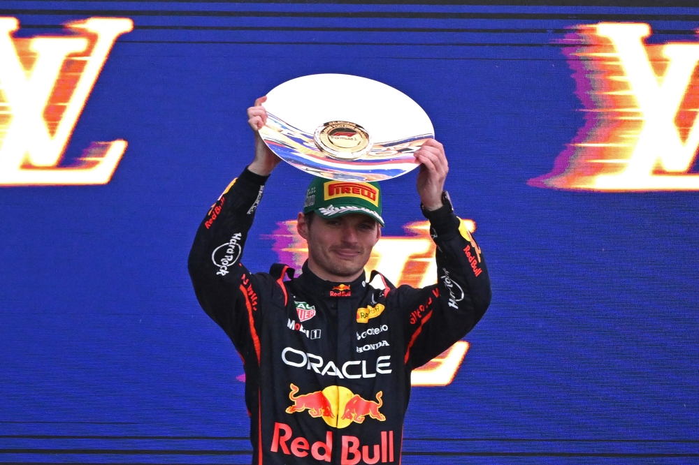 Second-placed Red Bull Racing's Dutch driver Max Verstappen celebrates on the podium with his trophy at the end of the Australian Formula One Grand Prix at Albert Park Circuit in Melbourne on March 16, 2025. (Photo by William West / AFP) 