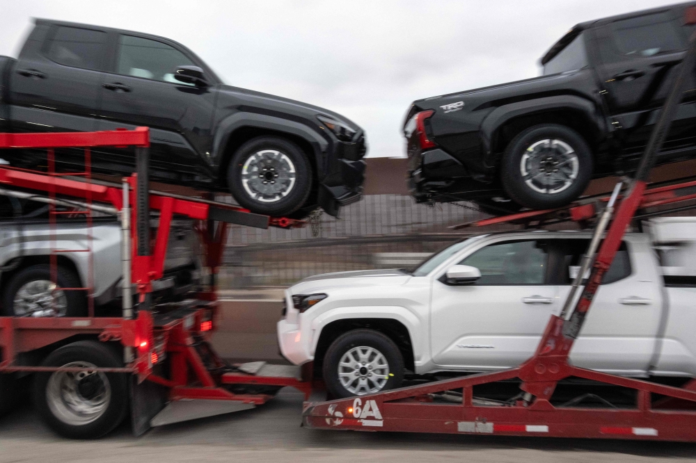 A cargo truck loaded with new pickups heads to US at the Otay Commercial crossing in Tijuana, Baja California state, Mexico on March 27, 2025. (Photo by Guillermo Arias / AFP)
