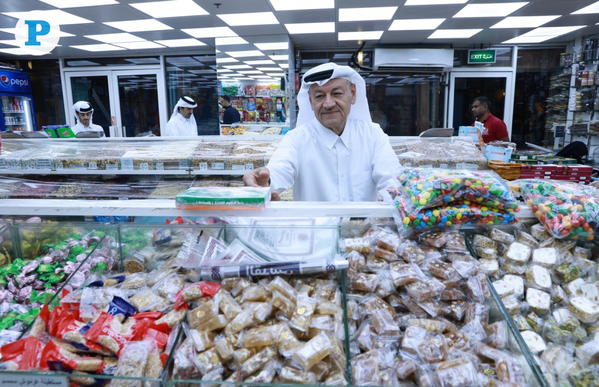 A shopper buying sweets at a local store ahead of the Eid Al Fitr celebration. Photo by Rajan Vadakkemuriyil / The Peninsula
