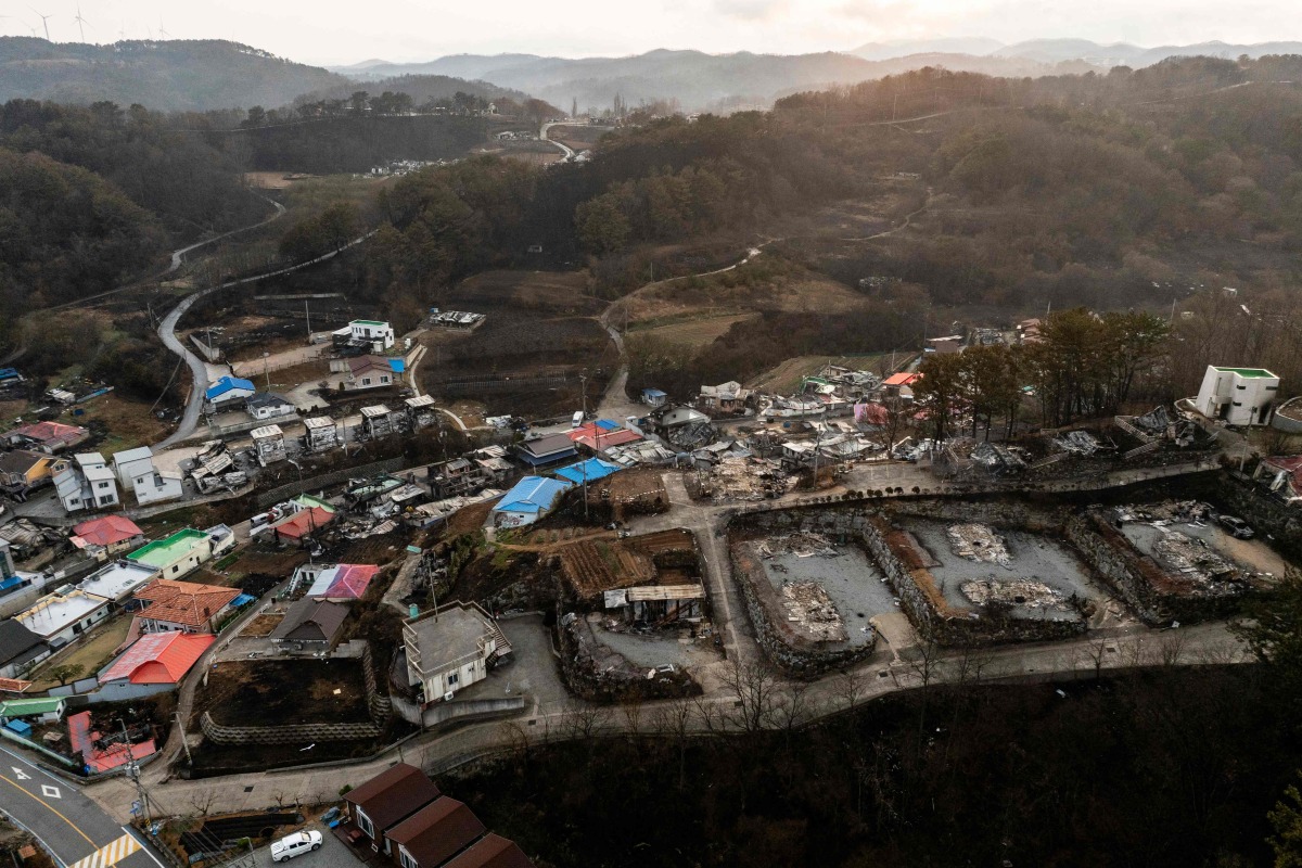 An aerial view shows properties ravaged by wildfires in the coastal village of Nomul-ri in Yeongdeok on March 28, 2025.  (Photo by ANTHONY WALLACE / AFP)