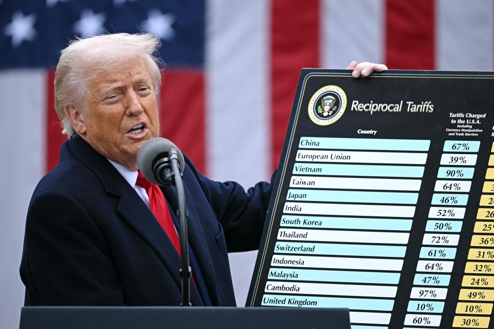US President Donald Trump holds a chart as he delivers remarks on reciprocal tariffs during an event in the Rose Garden entitled 