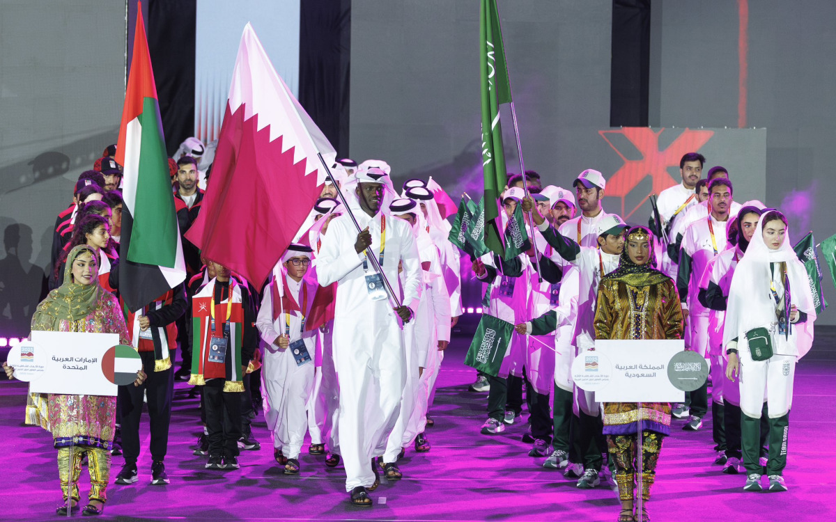 Beach volleyball star Cherif Younousse carries the Qatar flag during the opening ceremony.