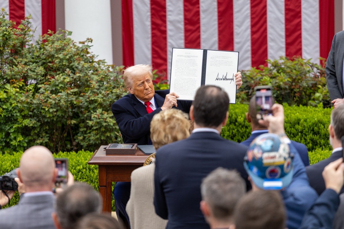 US President Donald Trump shows an executive order on 