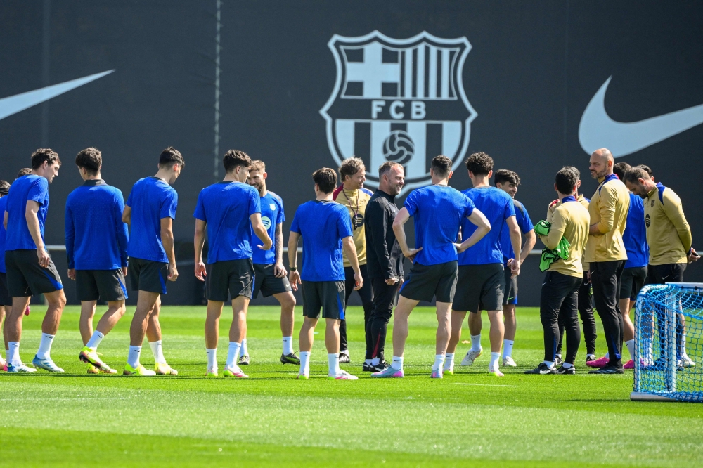 Barcelona's German coach Hans-Dieter Flick (C) and players attend a training session on the eve of the UEFA Champions League quarter final first leg football match between Barcelona and Borussia Dortmund at the Joan Gamper training ground in Sant Joan Despi, near Barcelona, on April 8, 2025. (Photo by Josep LAGO / AFP)